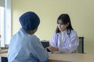 mulher paciente com câncer usando lenço na cabeça após consulta de quimioterapia e médico visitante no hospital.. foto