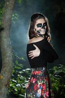 retrato de mulher de vampiro de halloween sobre fundo de noite assustadora. design de arte de moda de maquiagem de vampiro. garota modelo em traje de halloween e maquiagem. foto