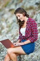 escritório ao ar livre. linda garota trabalha em um laptop ao ar livre. mulher freelancer. conceito de trabalhador autônomo. foto