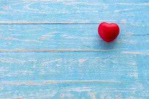 coração vermelho, conceito de amor. coração vermelho no fundo da mesa de madeira azul, estilo retrô vintage foto