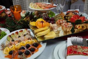 linda mesa festiva servida para jantar de festa de casamento em casa ou restaurante interior. mesa cheia de comida em um restaurante. mesa redonda completa. foto