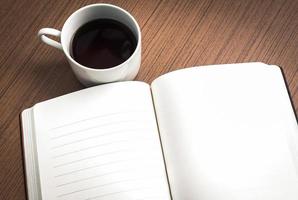 caderno vazio e café na mesa de madeira