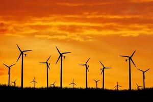 turbinas eólicas produzem eletricidade à noite. pôr do sol, silhueta, moinhos de vento, energia limpa à noite. alternativa de conceito renovável e energia limpa e eólica foto