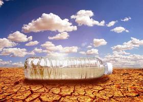 conceito de seca de escassez de água devido ao aquecimento global. garrafas de água colocadas em áreas de seca e solo quebrado foto