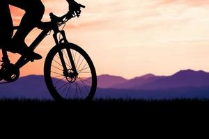 silhuetas de bicicletas de montanha e ciclistas à noite alegremente. conceito de viagens e fitness. silhueta de ciclistas em turnê no conceito de turismo de bicicleta à noite