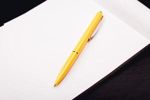 bloco de notas com caneta amarela foto