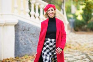 mulher sorridente com roupa elegante andando na rua foto