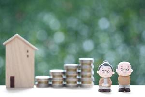 fundo mútuo, amor casal sênior e casa modelo com pilha de moedas dinheiro em fundo verde natural, economizar dinheiro para preparar no futuro e conceito de aposentadoria foto