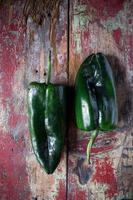 duas pimentas poblano verdes mexicanas na mesa pintada foto