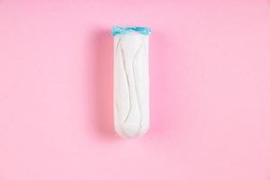 tampão de algodão higiênico em fundo rosa. produto de higiene menstrual feminina. foto