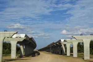 construção e lançamento de pilares de concreto para suportar o peso da ponte da via expressa - em construção para suportar a estrutura da ponte controlada por engenheiros civis para reduzir o deslocamento foto