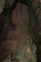 calcário de granito na caverna, mas a luz do sol brilha forte, mostrando as curvas e formas côncavas das rochas naturalmente belas de estalagmites e estalactites. foto