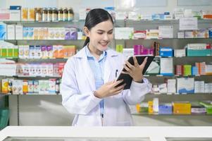 retrato de farmacêutico feminino usando tablet em uma farmácia de farmácia moderna. foto