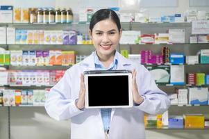 retrato de farmacêutico feminino usando tablet em uma farmácia de farmácia moderna. foto