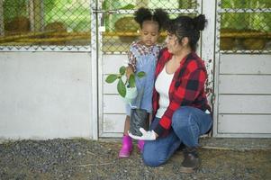 feliz mestiça mãe e menina agrônomo desfrutando e trabalhando em terras agrícolas, conceito de agricultura foto