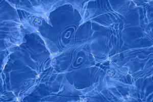 desfocar água azul turva na piscina ondulada água detalhe fundo. superfície da água no mar, fundo do oceano. a água é um inorgânico, transparente, insípido, inodoro e quase incolor. foto