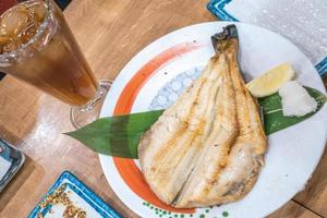 peixe cozido japonês no prato na mesa de madeira no restaurante japonês 24 horas aberto. foto