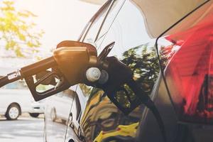 tanque de carro de reabastecimento com cabeça de bico de gasolina foto