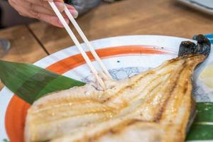 peixe cozido japonês no prato na mesa de madeira no restaurante japonês 24 horas aberto. foto