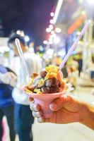 sorvete de sobremesa e cereais de café da manhã em cima na mão do homem no evento foodtruck e foodtreet., tailândia. foto