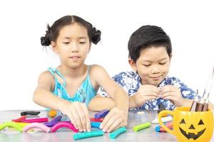 menino e menina estão alegremente brincando de brinquedo de barro foto