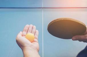 um homem joga tênis de mesa pronto para servir foto