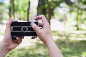 homem tirando foto usando câmera retrô antiga