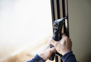 homem fazendo armação de alumínio com óculos e tela de arame trabalho de instalação de porta e janela no canteiro de obras foto