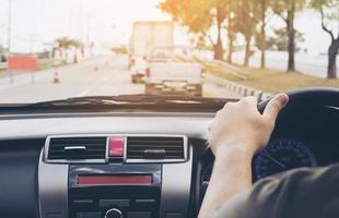 close-up de um homem dirigindo carro usando uma mão, comportamento perigoso foto