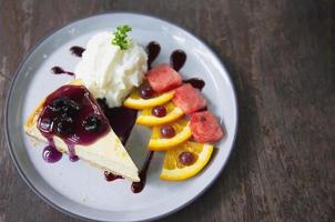 favor de mirtilo de bolo de queijo colorido com pedaços de frutas bem decorados e chantilly em chapa branca - conceito de menu de receita de bolo foto