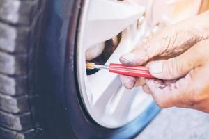 técnico está consertando pneu furado de carro foto