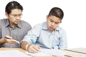 pai asiático ensinando lição de casa para seu filho de 14 anos a sério foto