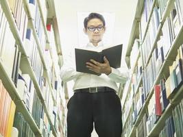 um homem está lendo um livro perto da biblioteca da estante foto