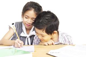 garoto está fazendo lição de casa juntos sobre fundo branco foto