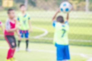 foto borrada de crianças estão praticando futebol no campo de futebol