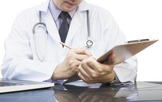 médico masculino anota um documento sobre fundo branco foto