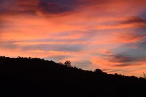 lindos céus cor de rosa com uma paisagem campestre em silhueta foto