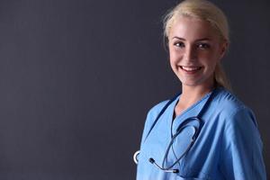 mulher jovem médico com estetoscópio isolado na cinza