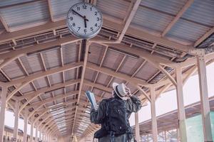 homem de viagem está esperando trem na estação de trem, chiangmai tailândia, 23 de maio de 2019 foto