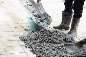 trabalhador fazendo trabalho de concretagem de piso no canteiro de obras foto