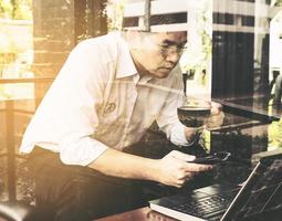 empresário está trabalhando com seu computador na cafeteria foto