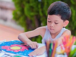 menino está pintando imagens coloridas em casa. foto está focada em seus olhos.