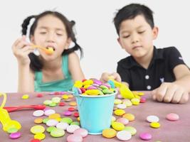 crianças asiáticas estão brincando com doces. foto é focada em doces.