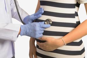 médico dando exame de saúde para mulher grávida foto