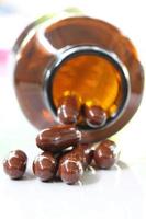 pílulas marrons e frasco de comprimidos. foto