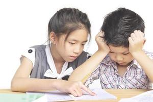 irmã tenta ensinar seu irmão mais novo impertinente a fazer lição de casa isolada sobre fundo branco foto