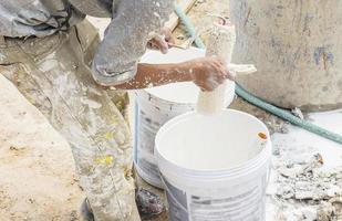 um pintor está lavando seu pincel rolante em um canteiro de obras, foco seletivo foto