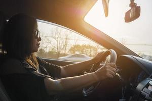 mulher dirigindo carro com as duas mãos foto
