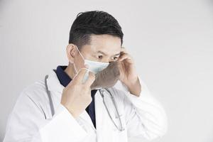 médico asiático está usando máscaras de camada dupla para proteger o vírus covid-19 - conceito de trabalho de pessoas médicas foto