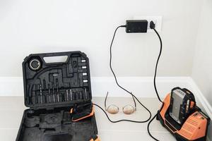 carregamento de bateria de parede para máquina de chave de fenda portátil, conceito de trabalho de construção de ferramentas manuais foto